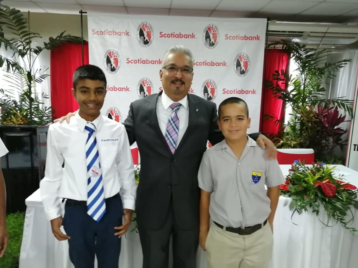 Captain Arshad Harrilal and Vice Captain Niall Maingot pose with Savon Persad, Vice-President Retail Banking and Small Business, Scotiabank, at the launch of the Scotiabank Nexgen U15 tournament.