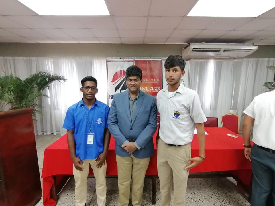 U17 captain Aiden Samaroo and player Sachin Emrit pose with Director of Price Club Supermarket Mr. Shamshad Ali.